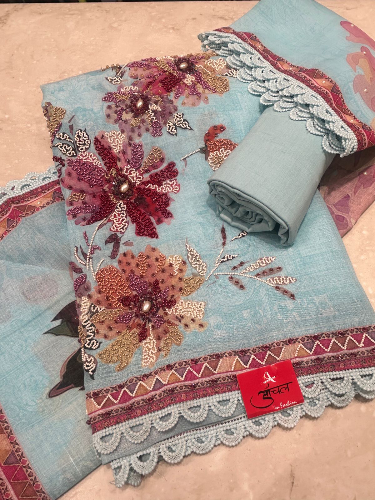 Mul fabric with floral patterns and a brand label on a beige surface